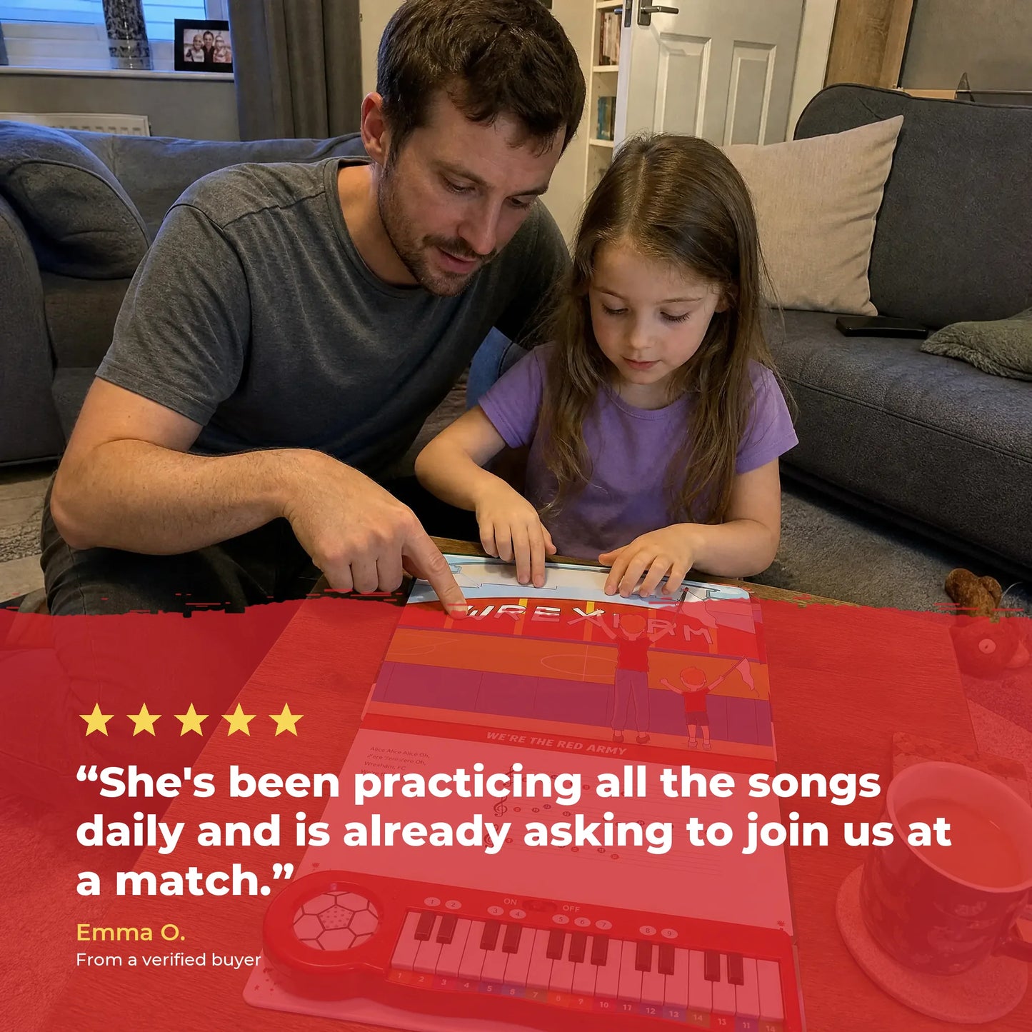 A father and his daughter at the table playing the Wrexham AFC Piano Book together, over a five-star review from a verified buyer.