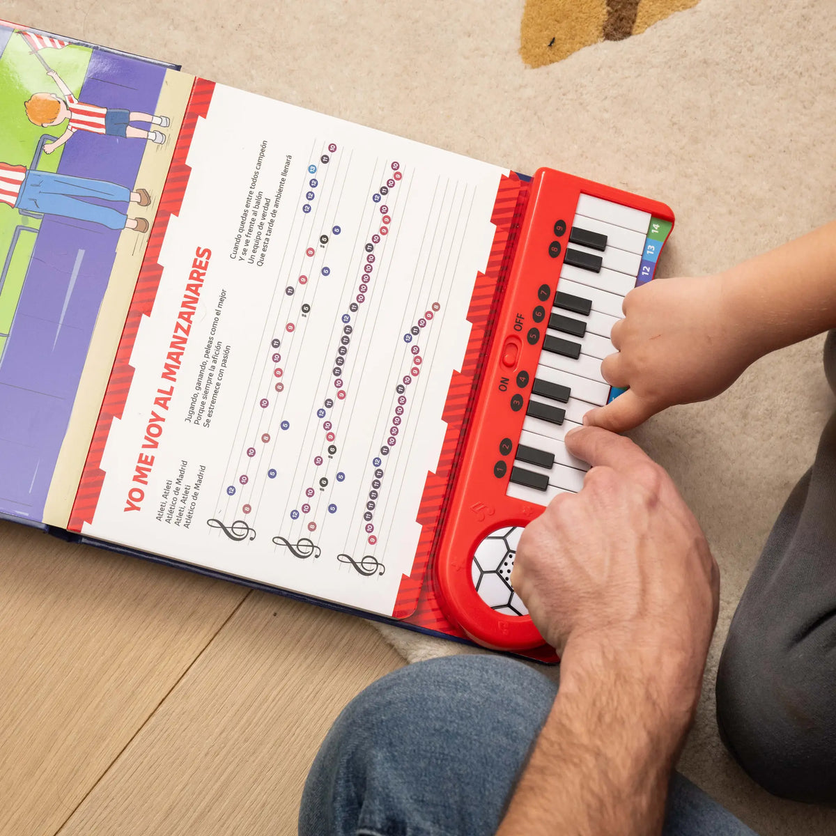 Un niño tocando en casa el Piano Libro del Atlético de Madrid.