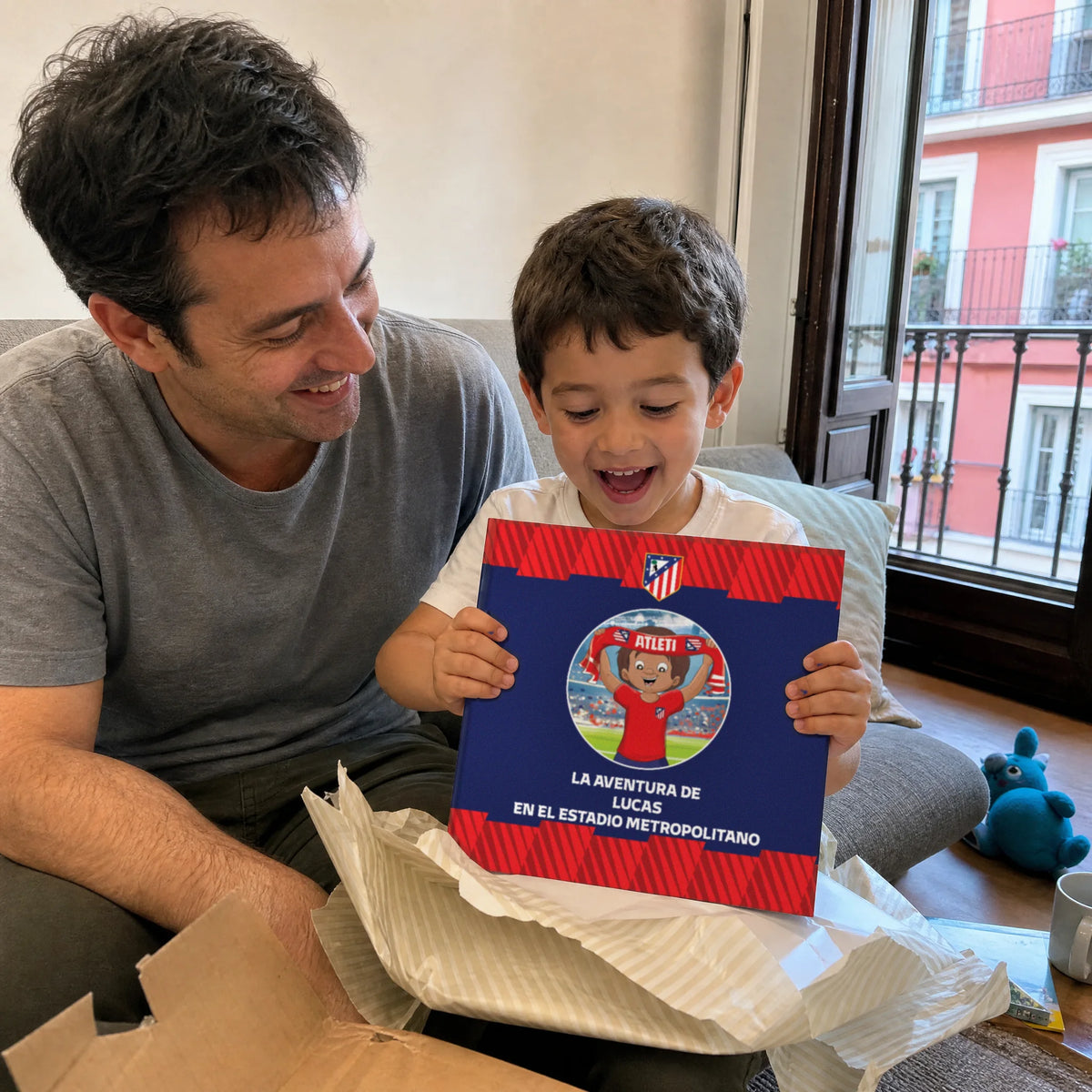 Un padre e suo figlio a casa a Madrid, il Libro Personalizzato dell'Atlético de Madrid appena uscito dalla carta da regalo.