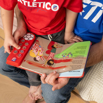 Un niño con la camiseta del Atlético pulsando en casa uno de los ocho botones de sonido.