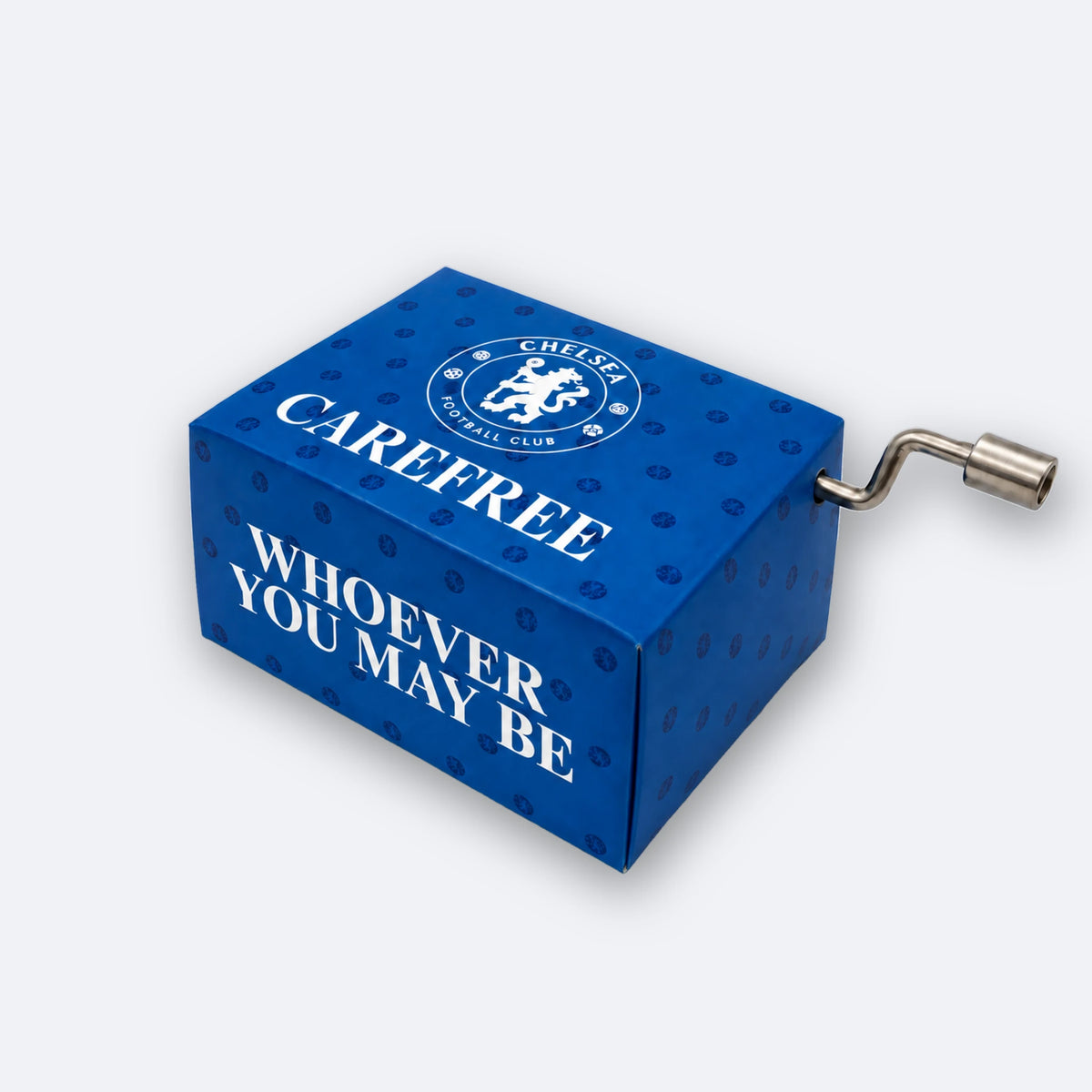 Carillon a manovella del Chelsea FC: una scatola blu reale con lo stemma del club e le scritte CAREFREE e WHOEVER YOU MAY BE, con una piccola manovella di metallo sul lato.