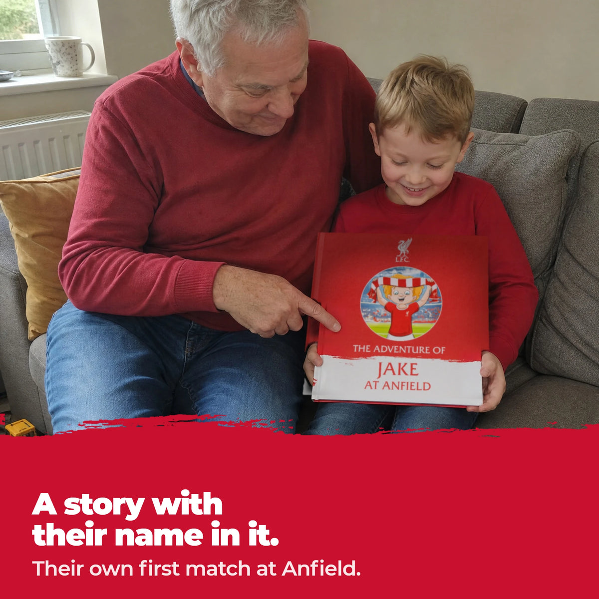 Ein Großvater und sein Enkel auf dem Sofa: der Großvater zeigt auf den Namen des Kindes auf dem Cover des personalisierten Liverpool-FC-Buchs.