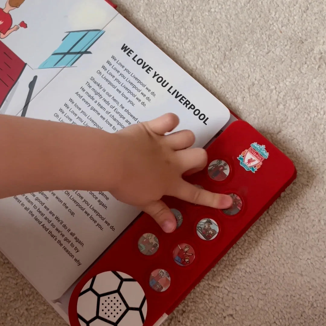A toddler pressing one of the eight sound buttons on the Liverpool FC Sound Book at home.