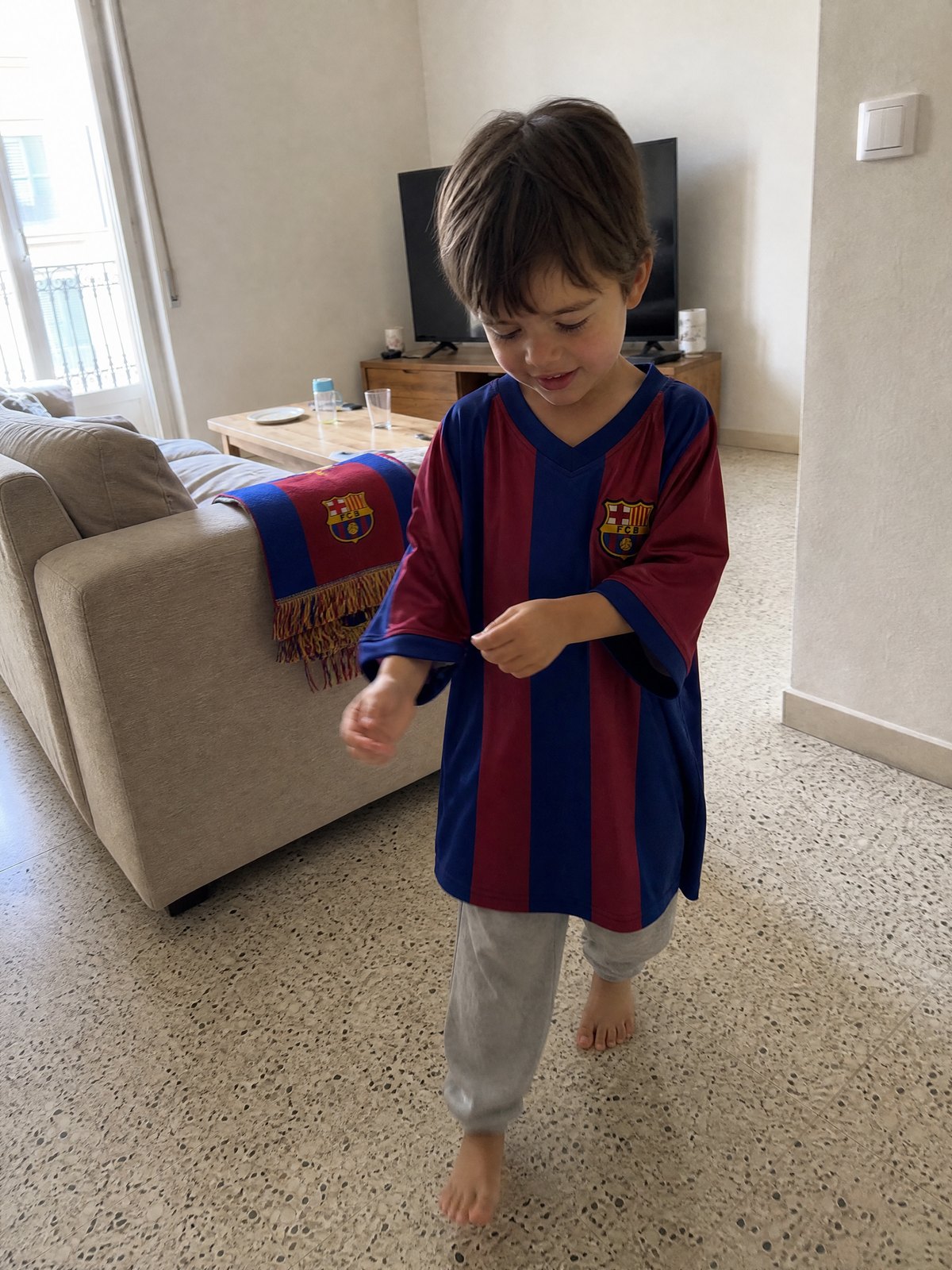 Jordi, cuatro años, con la camiseta del Barça cruzando el salón de casa