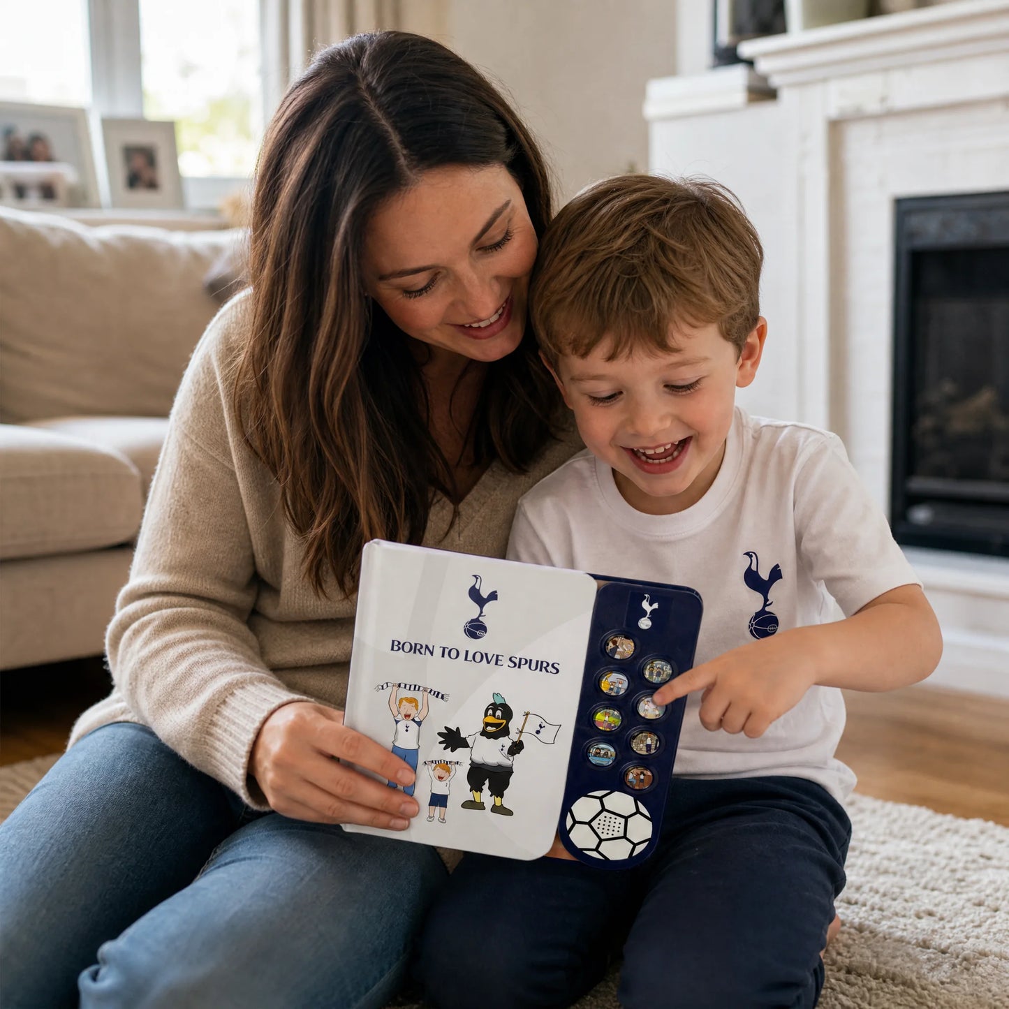 A mother and her son on the living-room floor, the boy pressing one of the eight sound buttons on the Tottenham Hotspur Sound Book.