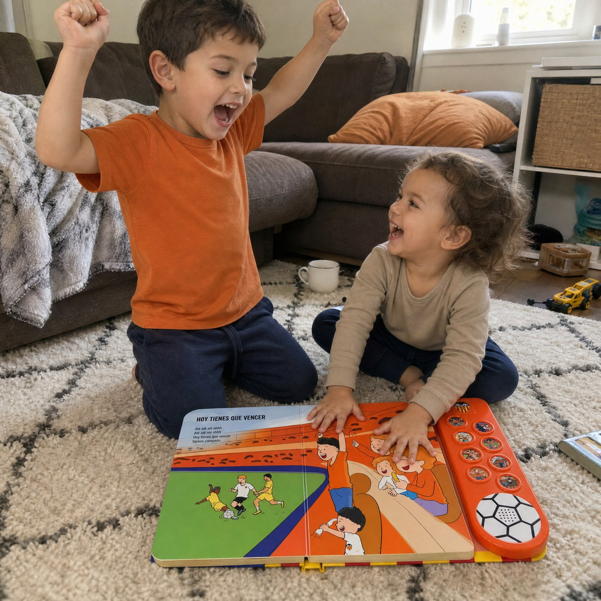 Dos hermanos en la alfombra con el Libro Musical del Valencia CF abierto en «Hoy tienes que vencer»: el mayor canta con los puños en alto y el pequeño apoya las manos en las páginas.