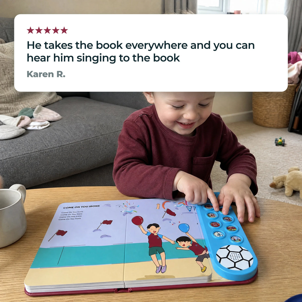 A young child in a plain claret top with the Sound Book open on a low table, a fingertip on one of the sound buttons, beside a five-star customer review.
