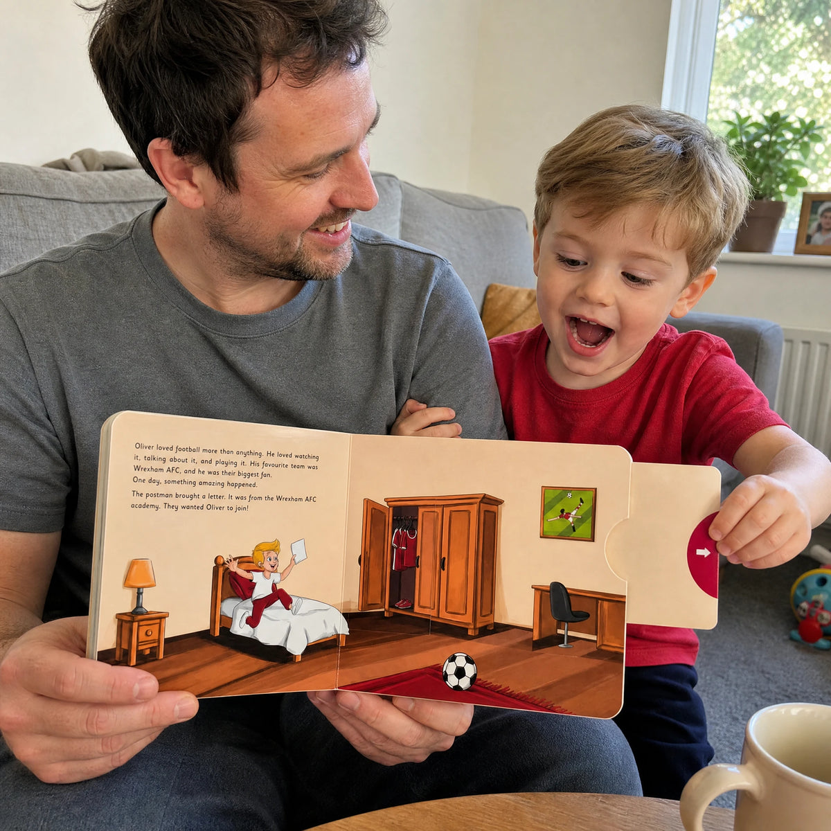 Un papà e il suo bambino sul divano, il bambino tira la linguetta rossa del Libro con Cursori del Wrexham