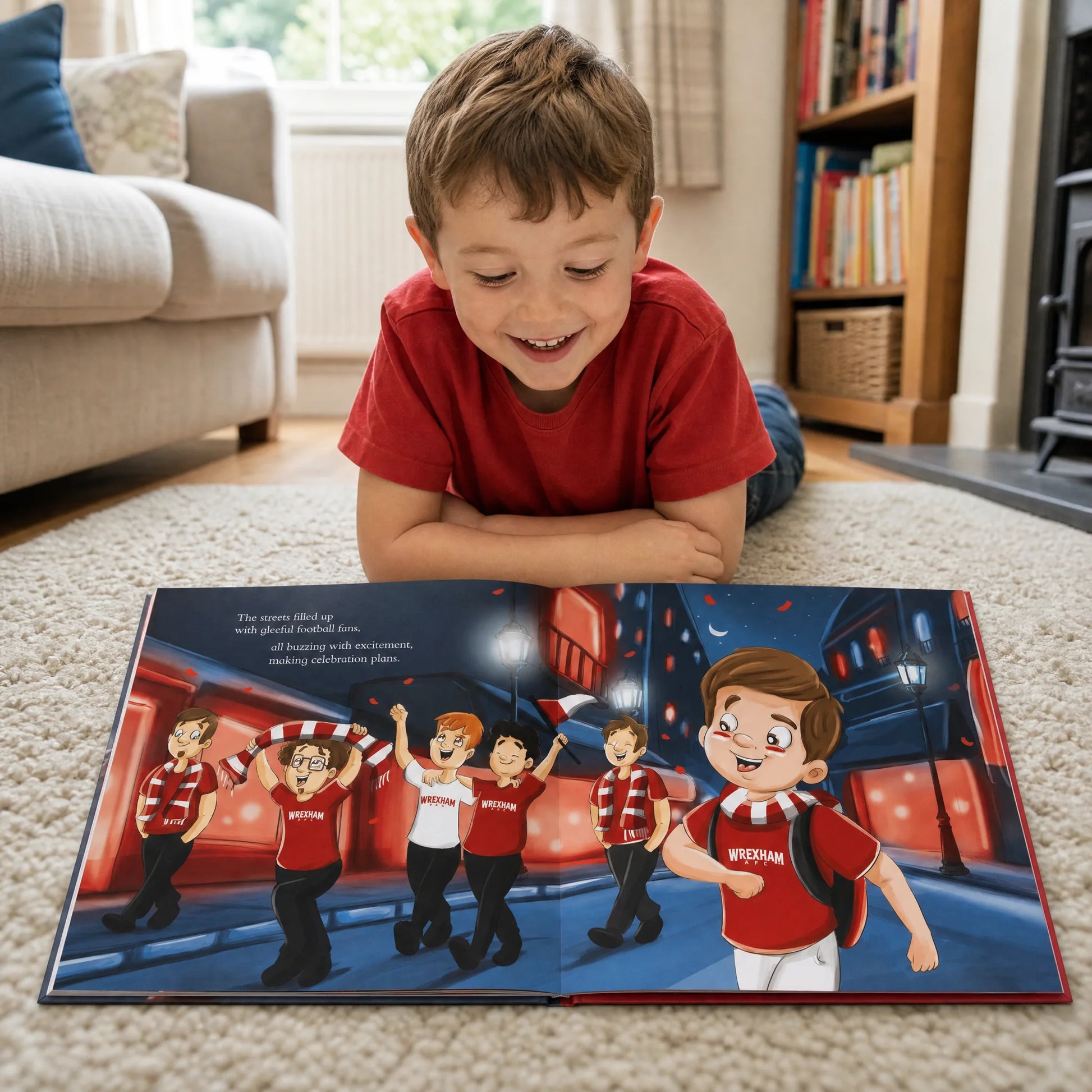 A boy lying on the living-room rug reading his Wrexham AFC Personalised Book, open at the spread where the streets fill with fans.