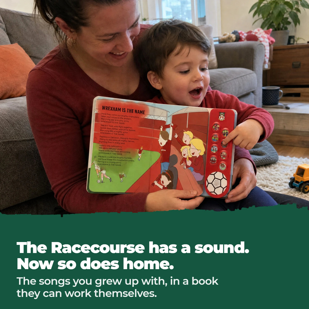 Una mamma e il suo bambino sul tappeto cantano insieme sul libro sonoro del Wrexham AFC aperto, il dito del bambino su uno dei pulsanti.