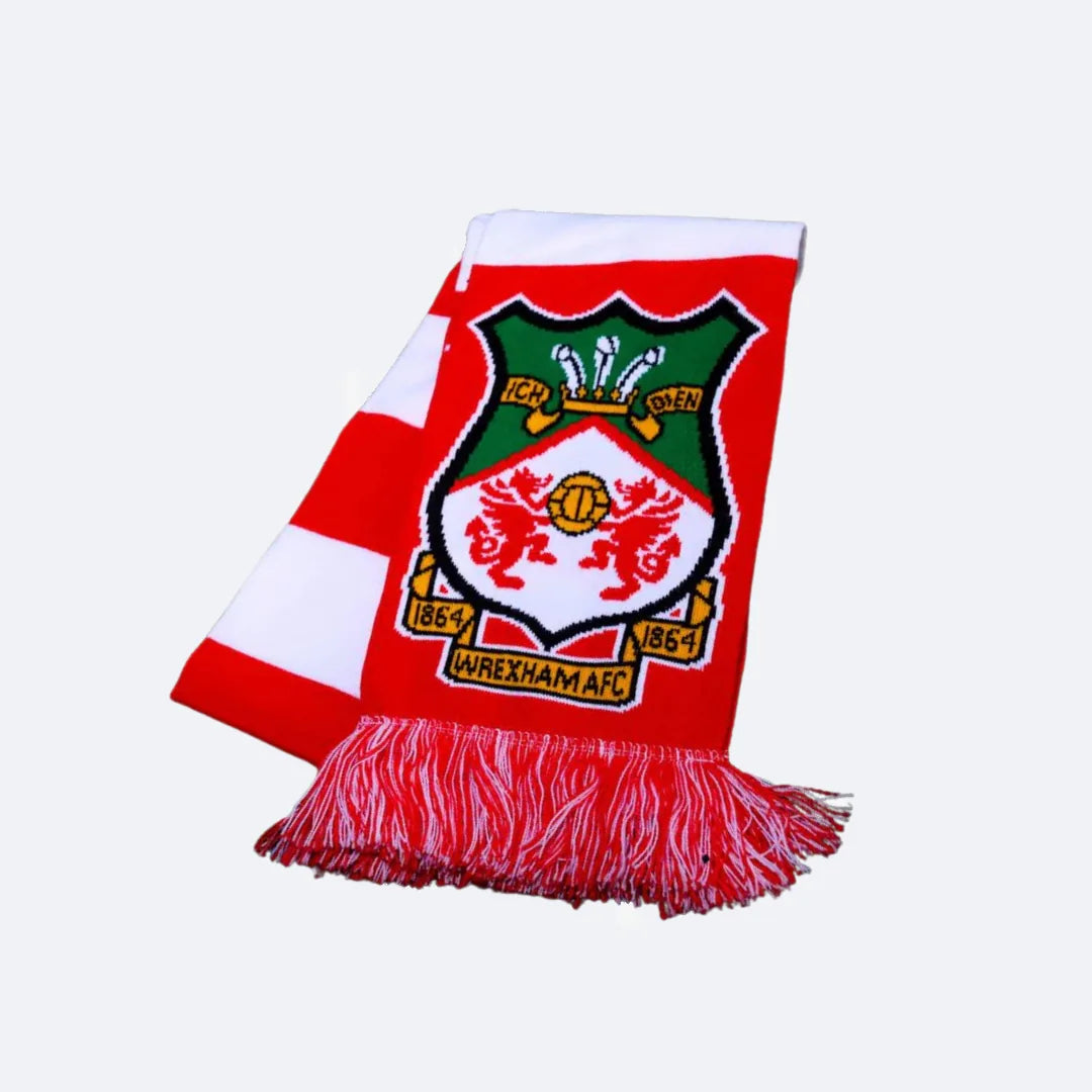Rot-weißer Bar-Schal von Wrexham AFC, gefaltet mit sichtbarem Vereinswappen, auf grauem Grund